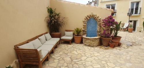 a patio with couches and potted plants and flowers at La Vista Secreta in Oria