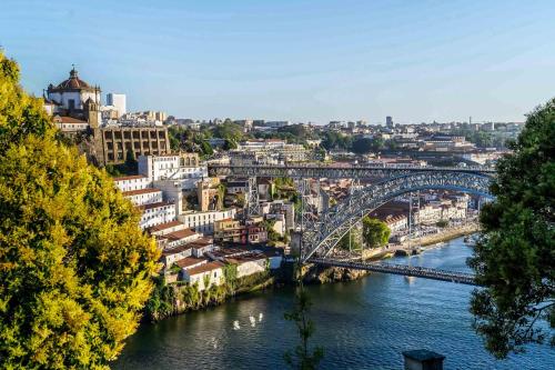 a bridge over a river next to a city at Herculano Stays Porto - Digital Access in Porto
