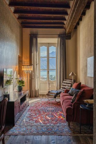 a living room with a couch and a large window at Villa Issima "The Menaggio Suite" - Menaggio by LoveComo in Menaggio