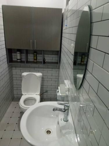 ein Badezimmer mit Toilette, Waschbecken und Spiegel in der Unterkunft Entebbe Katabi Regency Estate in Entebbe