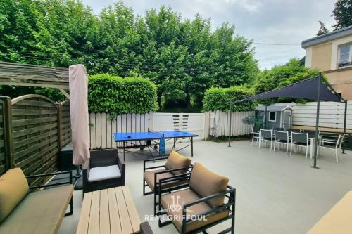 un patio avec une table, des chaises et un parasol dans l'établissement The Wall City Center Terrace & Parking 4 Guests, à Honfleur