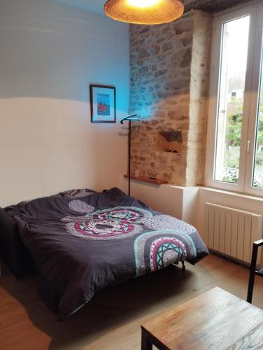 une chambre avec un lit et un mur de briques dans l'établissement studio moderne les pieds dans l'eau, à Larmor-Baden