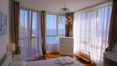 Un dormitorio con una cama y una ventana grande. en Апартаменти Бяла Клиф - Byala Cliff Apartments, en Byala