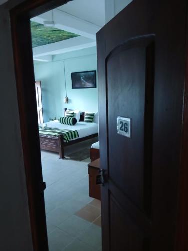 a door leading to a bedroom with a bed at Green Peak - Mountain View Hotel & Restaurant in Ella
