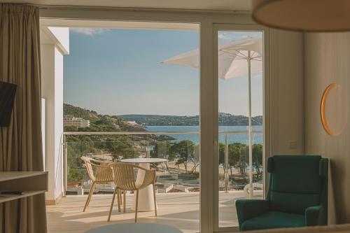 a room with a balcony with a view of the ocean at Aparthotel Novo Mar in Paguera