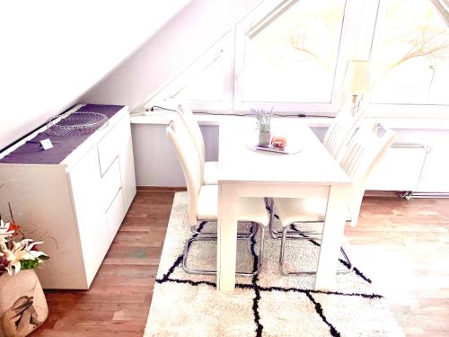 a white table and chairs in a kitchen with a window at Ferienhaus Am Achterwasser in Ueckeritz