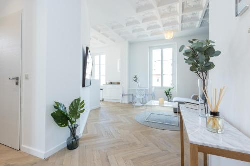 Il comprend un salon doté de murs blancs et de parquet. dans l'établissement 4 FRANCE - Magnifique 2p - Carre d Or - Clim, à Nice
