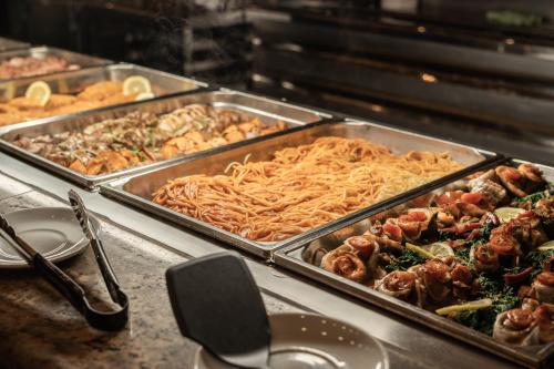 a buffet with trays of food on a table at Yomo Patagonia in Arinsal