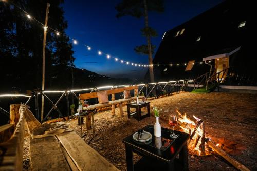 a fireside area with a bench and a table and a fire sidx sidx at SaffronStays Bagh Kufri in Kūfrī