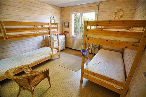 Cette chambre comprend 2 lits superposés et une chaise. dans l'établissement Maison des Pins, à Arcachon