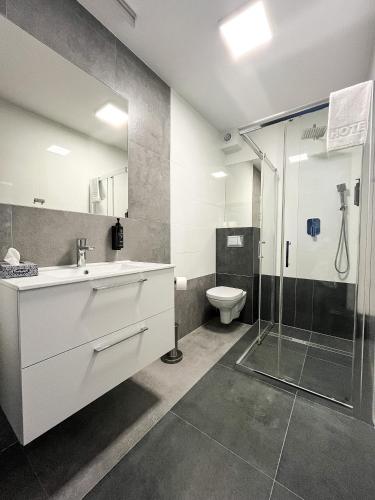 a bathroom with a sink and a shower and a toilet at Hotel Sobieraj in Krzeszyce