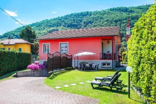 a red house with a table and chairs in the yard at Casa Ponte Ballerino in Cannobio