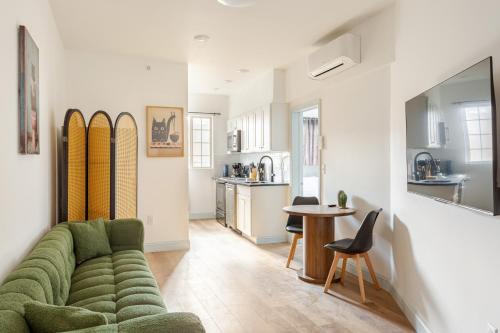 a living room with a green couch and a table at Cozy Stay Near Fishtown - Close to Subway & Center City! in Philadelphia