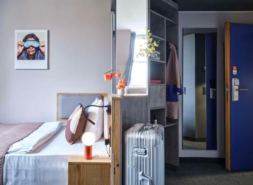 a hotel room with a bed and a suitcase at Flemings Hotel Frankfurt-Central in Frankfurt/Main