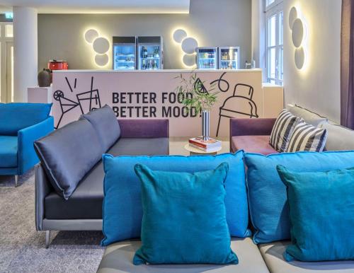 a living room with a couch and blue pillows at Flemings Hotel Frankfurt-Central in Frankfurt/Main