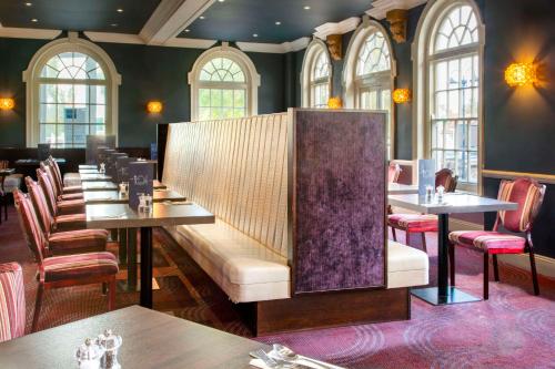 a restaurant with a row of tables and chairs at London Croydon Aerodrome Hotel, BW Signature Collection in Croydon