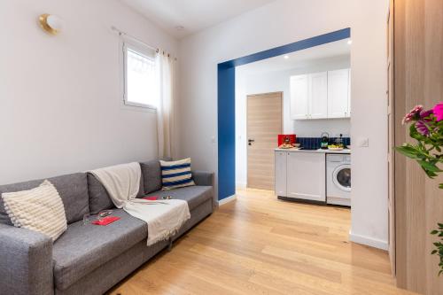 a living room with a couch and a kitchen at Lavie Maison Sauna and Hot Tub Seaside in Nice