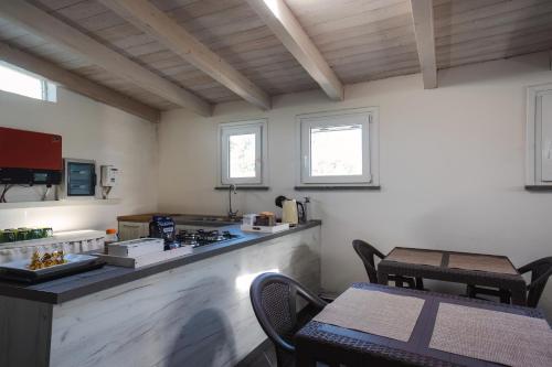 a kitchen with a counter and a table and chairs at Mi casa es tu casa 104 in Portoscuso