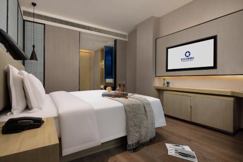 Un ou plusieurs lits dans un hébergement de l'établissement Starry Sky Garden Hotel Wuhan Hankou Railway Station Zhuyeshan Subway Station Branch