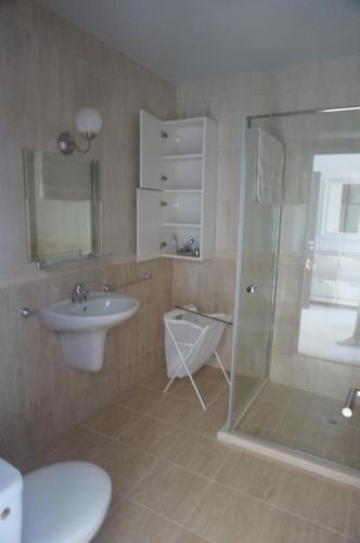 Un baño con ducha, inodoro y lavabo. en Апартаменти Бяла Клиф - Byala Cliff Apartments, en Byala