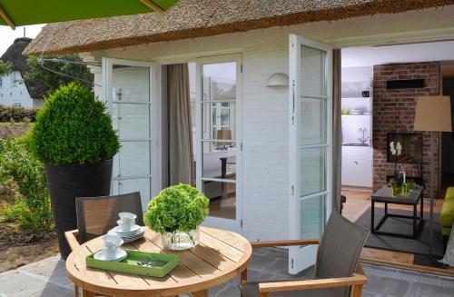 a patio with a table and chairs and a house at Benen-Diken-Hof in Keitum