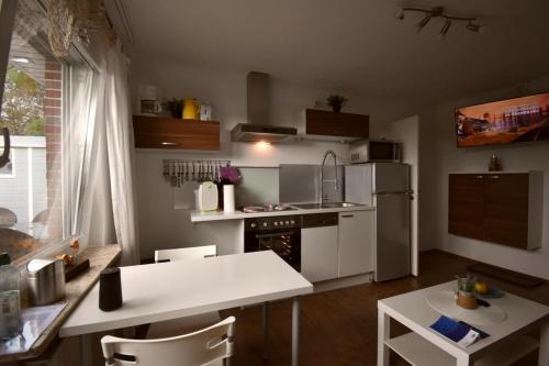 ドルヌムにあるFerienwohnung Border Collieの白い家電製品とテーブルと椅子を備えたキッチン