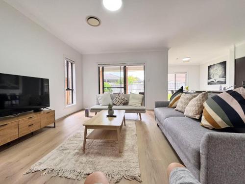 a living room with a couch and a tv at Blue Haven Retreat - Thornton Central 60 in Penrith