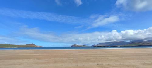 a beach with mountains in the distance and the ocean at Granville House Apartments and Garden Suites in Ballyferriter