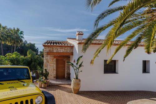 a yellow truck parked in front of a white house at The Villa by Los Limoneros in Teulada