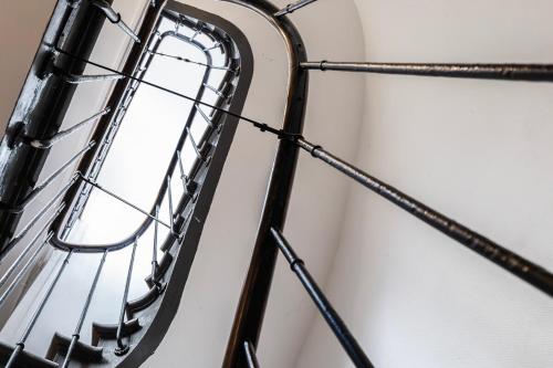 un escalier en colimaçon avec une fenêtre sur un mur blanc dans l'établissement Lovely studio in the heart of Montmartre, à Paris