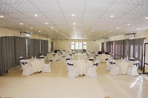 ein Bankettsaal mit weißen Tischen und weißen Stühlen in der Unterkunft Hotel Chautari pvt ltd in Nagarkot