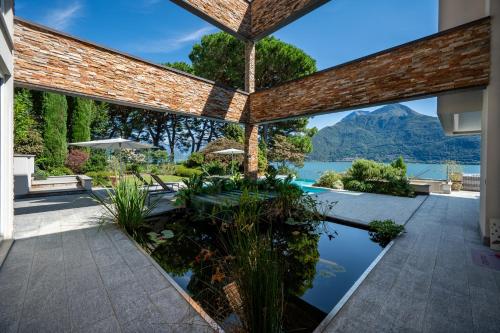 an external view of a house with a pool and mountains at Villa Koi - where luxury meets serenity in Pianello Del Lario