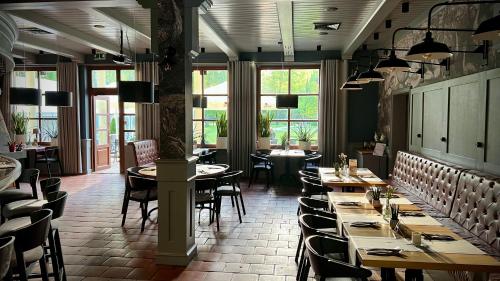 a dining room with tables and chairs and windows at Hotel Prezydent in Spała