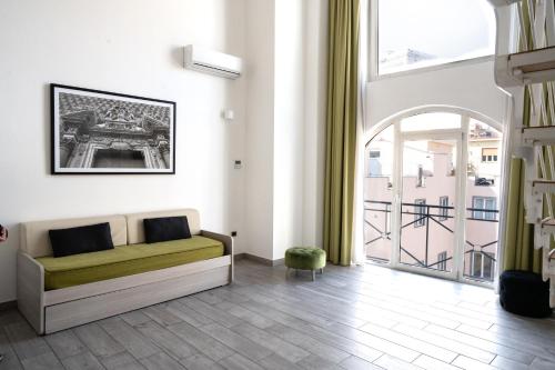 a living room with a couch and a large window at Ecumano Space in Naples