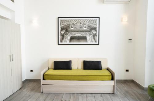 a bed in a room with a picture on the wall at Ecumano Space in Naples