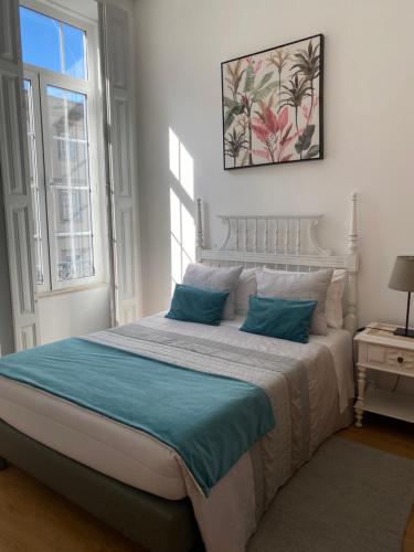 a bedroom with a large bed with blue pillows at Guest house D. Filipe I in Porto