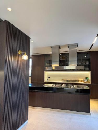 a kitchen with brown cabinets and a black counter top at Dabouq Luxurious Penthouse in Amman