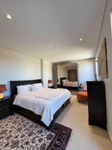 a bedroom with a large bed and a large mirror at Dabouq Luxurious Penthouse in Amman