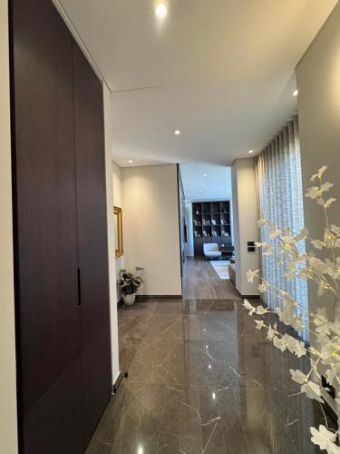 a hallway of a home with a door and tile floor at Dabouq Luxurious Penthouse in Amman