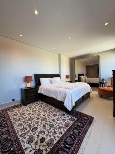a bedroom with a large bed and a rug at Dabouq Luxurious Penthouse in Amman