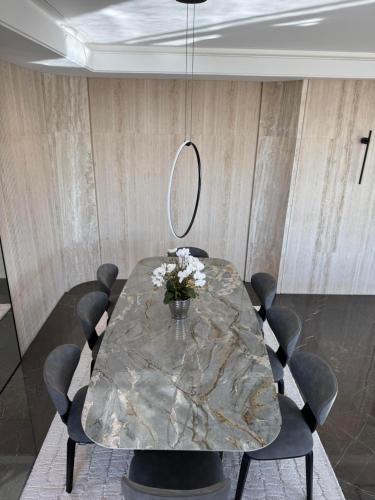 a dining room with a marble table and chairs at Dabouq Luxurious Penthouse in Amman
