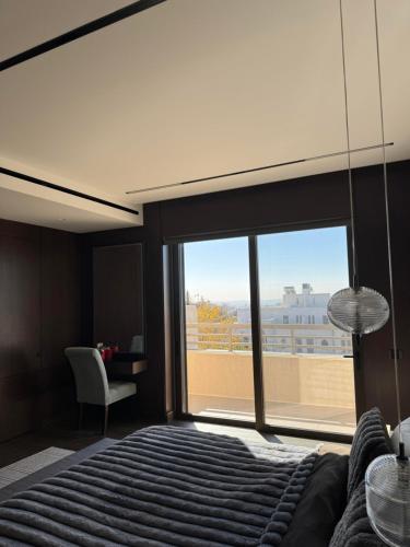 a bedroom with a bed and a large window at Dabouq Luxurious Penthouse in Amman