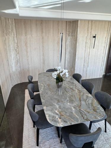 a dining room with a marble table and chairs at Dabouq Luxurious Penthouse in Amman