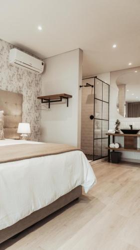 a bedroom with a large bed and a bathroom at 55 Tulbagh events and wedding venue in Kempton Park
