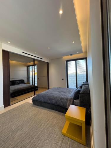 a bedroom with a bed and a couch and a mirror at Dabouq Luxurious Penthouse in Amman