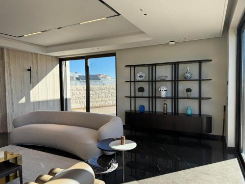 a living room with a couch and a table at Dabouq Luxurious Penthouse in Amman