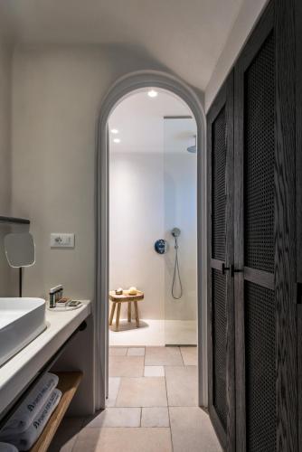 a bathroom with a shower and a sink at Porto Fira Suites in Fira