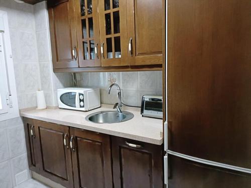 a kitchen with a sink and a microwave at Apartamento Candari Playa en Cadiz in Cádiz