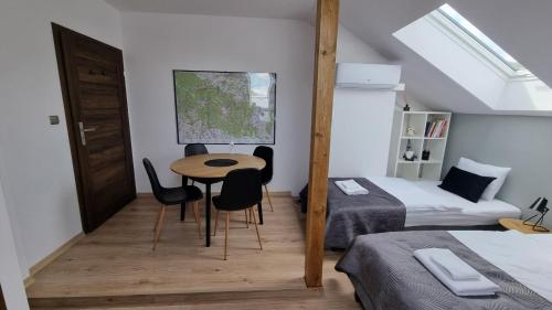 a bedroom with a table and chairs in a room at Spokojna Sosnówka in Sosnówka