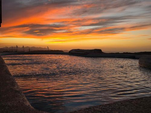 a sunset over a body of water with wind turbines at Casona Cocobolo el mejor lugar de Costa Rica in Guanacaste